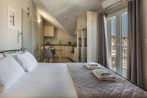 sypialnia z dużym białym łóżkiem z ręcznikami w obiekcie Fidias city rooms w mieście Argostoli