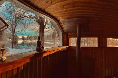 a window in a cabin with a view of a lake at Romantic Cabin right on the lake with fire place in Stjärnsund