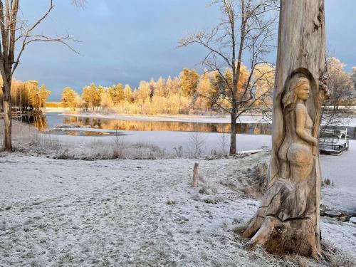 a statue of a woman on a telephone pole in the snow at Romantic Cabin right on the lake with fire place in Stjärnsund