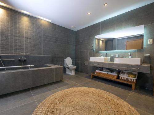 a bathroom with two sinks and a tub and a toilet at Ferenity in Iraklitsa