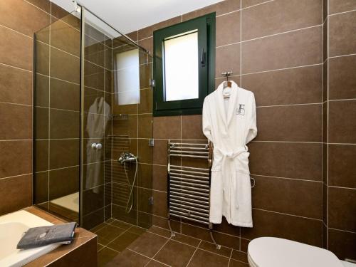 a bathroom with a white robe hanging on a wall at Ferenity in Iraklitsa
