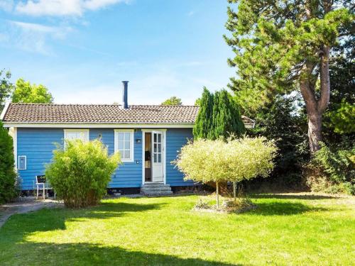een blauw huis met bomen in de tuin bij 6 person holiday home in Slagelse in Slagelse