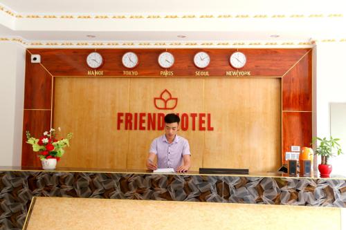 un hombre de pie en una recepción en una oficina de bomberos en Friend Hotel Hà Giang, en Ha Giang