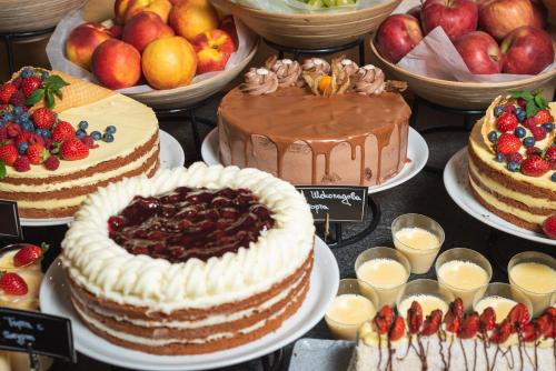 a display of cakes and other desserts on plates at Hotel Arte SPA & Park in Velingrad