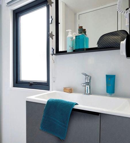 - un lavabo avec une serviette bleue dans l'établissement Camping l'Oso, à Porto-Vecchio