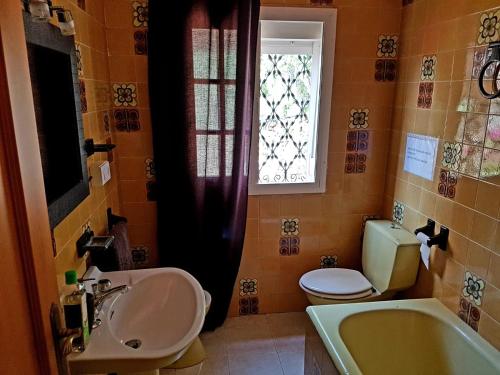 baño con lavabo y aseo y ventana en Villa Marver, en Algeciras