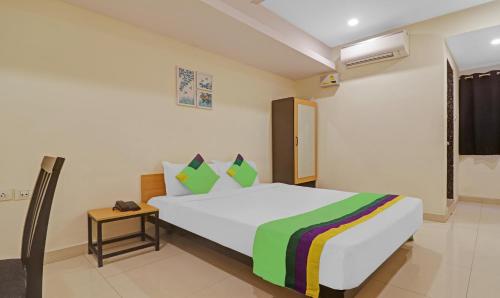 a bedroom with a large bed and a night stand at Treebo Tee in Hyderabad