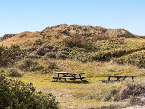 dos mesas de picnic sentadas en la cima de una colina en 8 person holiday home in Hirtshals en Hirtshals