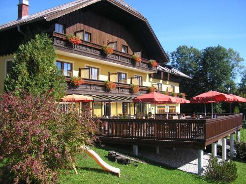 a large building with red umbrellas in front of it at Hotel-Pension Schwaighofen in Eugendorf