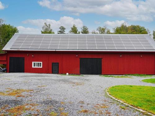 a red barn with a solar panel on it at 4 person holiday home in Mellösa in Mellösa