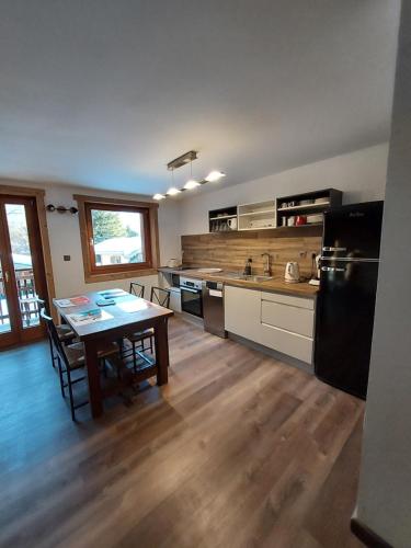 a kitchen with a table and a kitchen with a refrigerator at La Chaine du Mont-blanc in Chamonix-Mont-Blanc