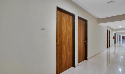 a hallway with two wooden doors in a building at Treebo Tee in Hyderabad