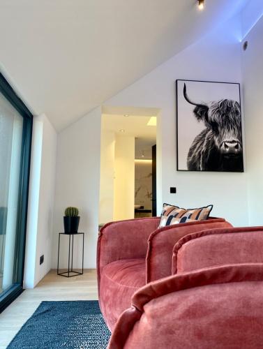 a living room with a couch and a picture of a bull at Le Clos du Verger in Aubel