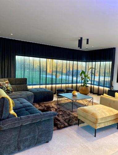 a living room with a couch and a table at Le Clos du Verger in Aubel