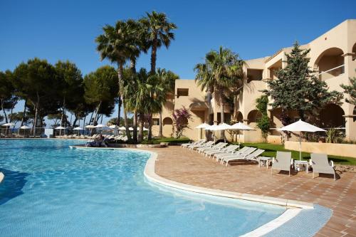 a pool at a resort with chairs and umbrellas at Grupotel Santa Eulària & Spa - Adults Only in Santa Eularia des Riu