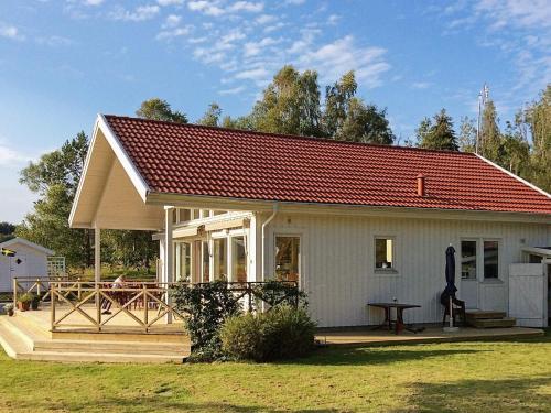 Cabaña blanca pequeña con techo rojo en 6 person holiday home in BRASTAD, en Brastad