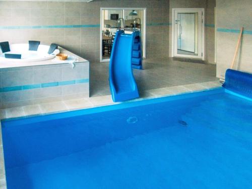 een zwembad met een blauwe glijbaan in een badkamer bij 18 person holiday home in V ggerl se in Bøtø By