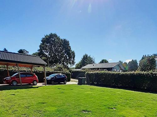 dos autos estacionados en un patio al lado de una casa en 6 person holiday home in Malling, en Malling