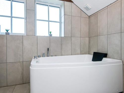 een badkamer met een wit bad en ramen bij 6 person holiday home in Ansager in Ansager