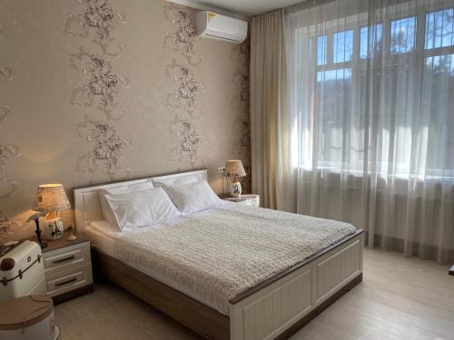 a bedroom with a large bed and a window at Guest House near Kolonnady in Kislovodsk