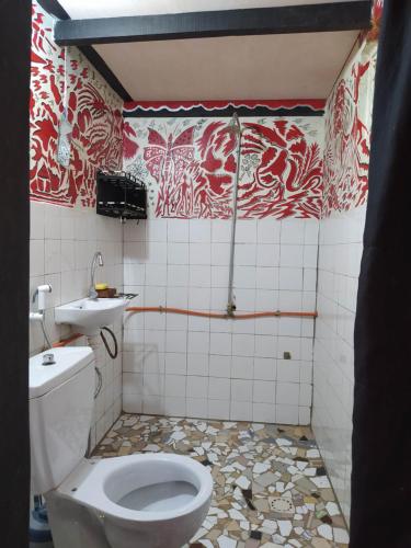 a bathroom with a toilet and a sink at Chez Yaya - Grande Chambre in Oussouye