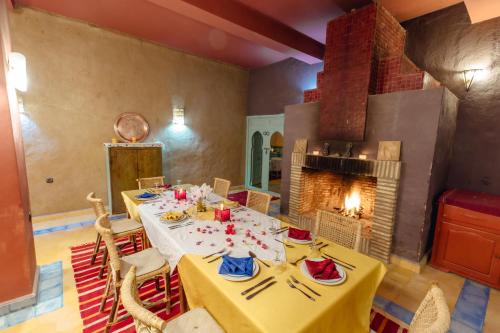 una sala da pranzo con tavolo e camino di Dar El Janoub a Merzouga