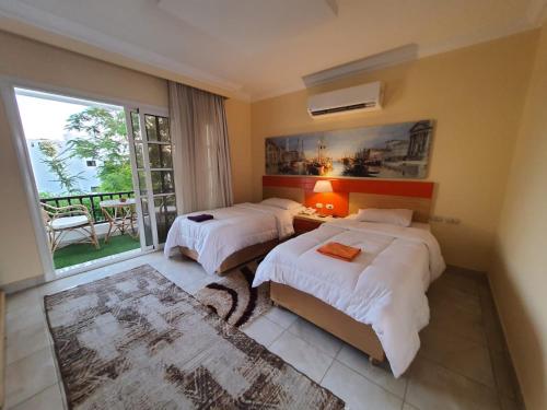 a hotel room with two beds and a balcony at Delta Sharm Apartments with free Internet Wi-Fi in Sharm El Sheikh