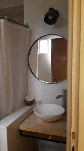 y baño con lavabo blanco y espejo. en Cala Hotel en Mar del Plata