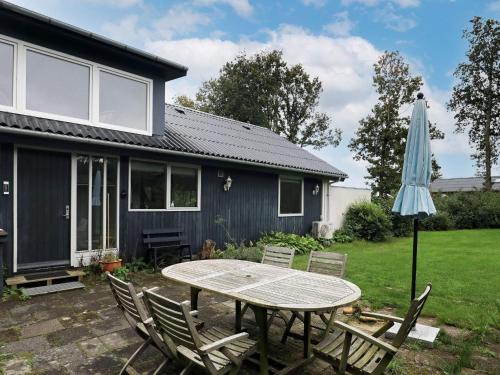 a patio with a table and an umbrella at 6 person holiday home in Roslev in Roslev