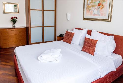 a bedroom with a bed with white sheets and pillows at Hotel Pushkin in Uralsk
