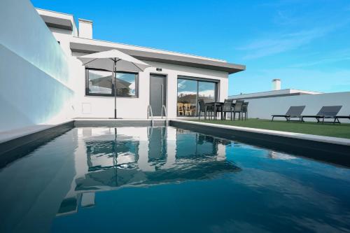 a swimming pool in front of a house at Queen Villa - Santa Barbara - Lourinha in Santa Barbara