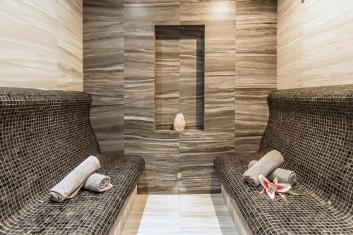 two wicker chairs in a room with wooden walls at Hotel Arte SPA & Park in Velingrad