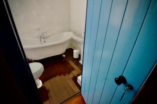 een badkamer met een bad, een toilet en een wastafel bij Victoria Titanic 1912 cottage in Belfast