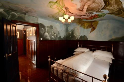 a bedroom with a large painting on the ceiling at Victoria Titanic 1912 cottage in Belfast