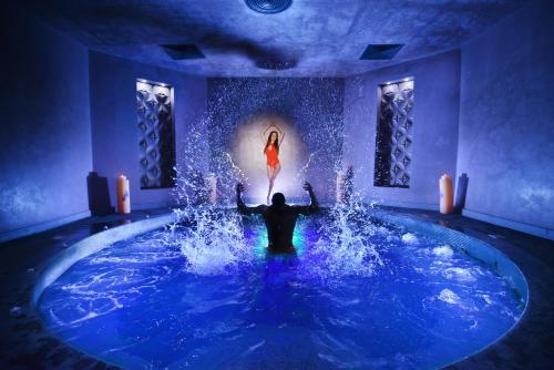 a woman in a red dress in a pool of water at Hotel Arte SPA & Park in Velingrad