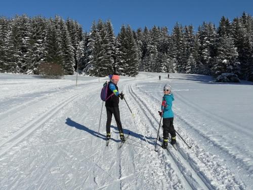 a woman and a child on skis in the snow at Pension MAX in Pernink