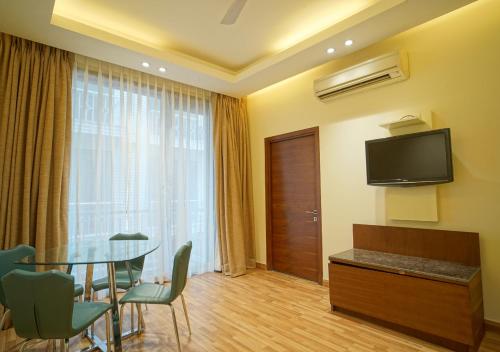 une chambre d'hôtel avec une table et une télévision dans l'établissement UDS Villa Scandinavian B&B - Next to VFS, à New Delhi