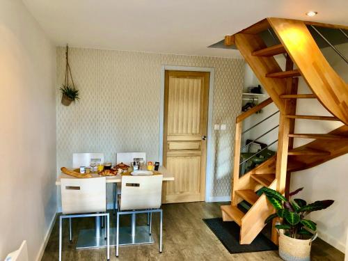 a kitchen with a table and a staircase in a room at Les gîtes de Joséphine in Courbouzon