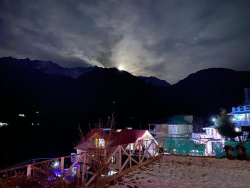 a view of a mountain with the moon in the sky at Hotel Victoriya Palace,Mcleod Ganj in McLeod Ganj