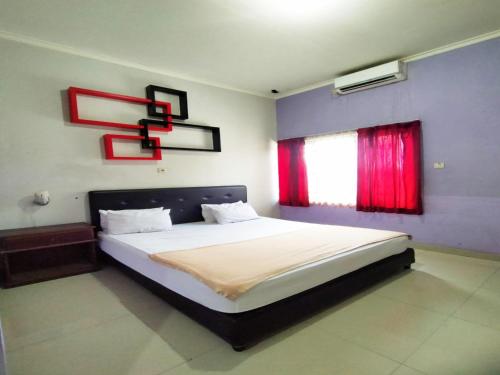 een slaapkamer met een groot bed en een raam bij RedDoorz at Hotel Nuansa Ngawi in Ngawi