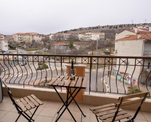a balcony with two chairs and a table with a wine glass at The Teal Studio in Kozani in Kozani