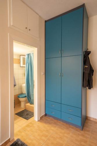 a blue cabinet in a bathroom with a toilet at The Teal Studio in Kozani in Kozani