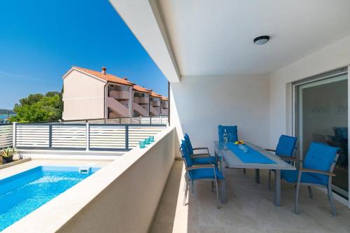 a balcony with a table and chairs and a swimming pool at Pool Apartment Sax in Medulin