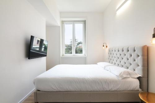 a white bedroom with a bed and a window at Contempora Apartments - Turati 3 One Bedroom Apartment in Milan