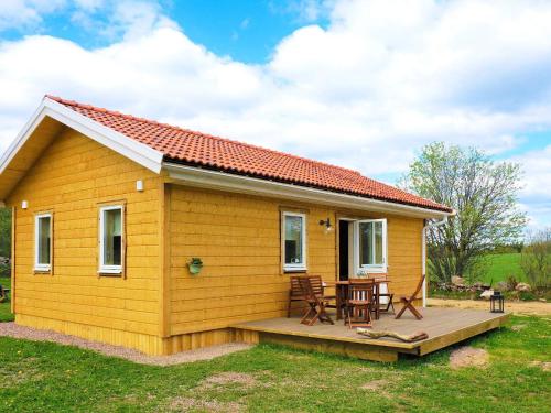 une petite maison jaune avec une terrasse et une table dans l'établissement 4 person holiday home in SANDHEM, à Sandhem