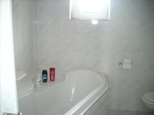 een witte badkamer met een bad en een toilet bij Ubytování v soukromí Frenštát in Frenštát pod Radhoštěm
