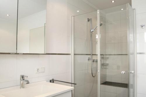 a white bathroom with a shower and a sink at Wrede in Wenholthausen