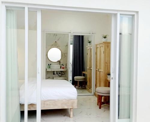 a bedroom with a bed and a mirror at Villa Mosel Bali in Banjar