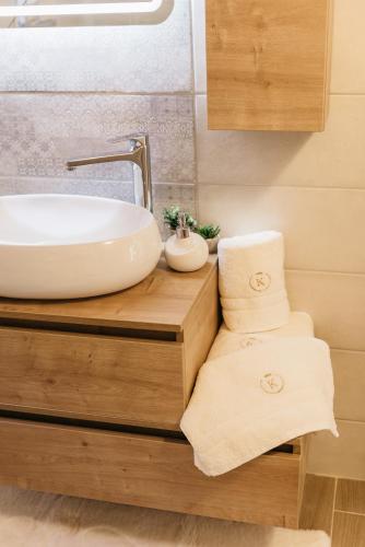 a bathroom with a sink on a wooden counter with towels at Krolo Villa&Wine in Trilj