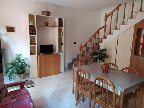 sala de estar con mesa, sillas y escaleras en Vanedda monile (casa centro storico), en Módica